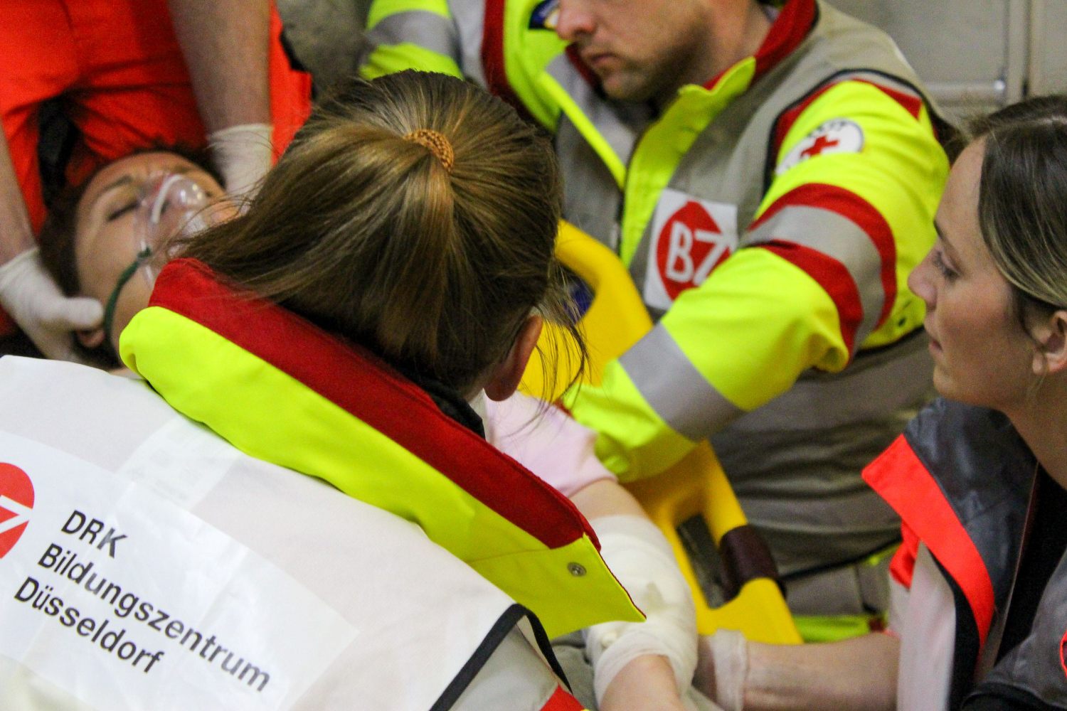 Team von Notfallsanitätern versorgt eine Patientin.